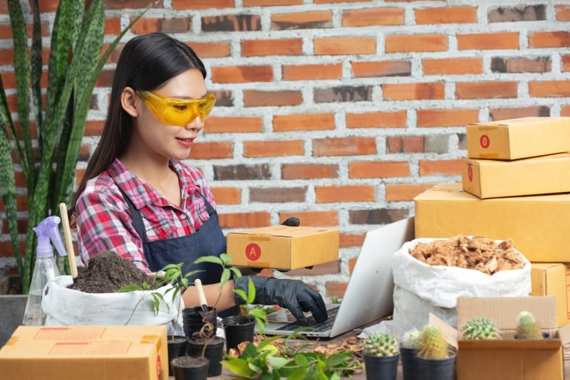 selling plant online; women smiling while using laptop